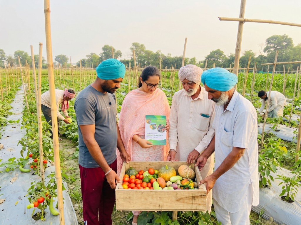 Mandeep Kaur Chahal with FamFarmer ethical farmers holding a fresh harvest in the field